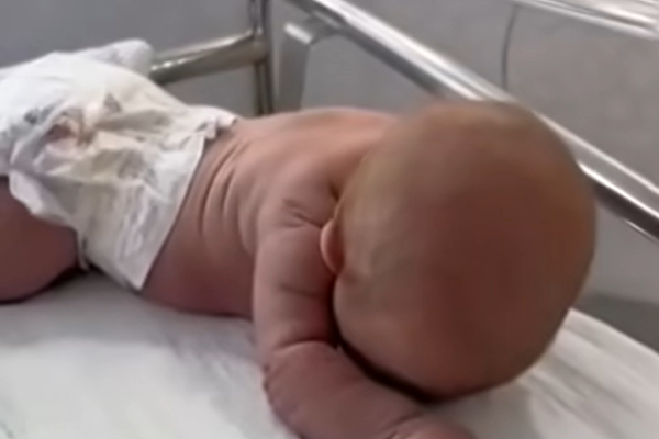 Newborn baby crawls across the hospital cot